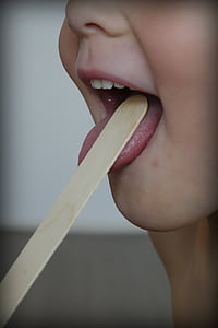 person sticking tongue on brown popsicle stick thumbnail