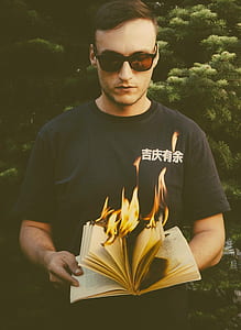 man holding burning book thumbnail