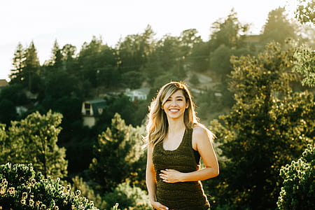 woman standing near green leafed trees thumbnail