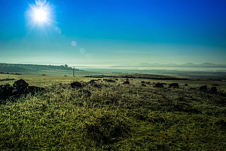 lawn field near mountain cliff landscape photography thumbnail