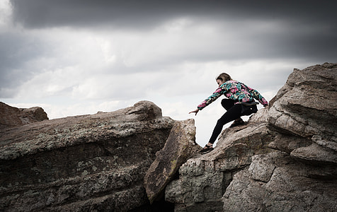 woman in black pants climbing rocks thumbnail