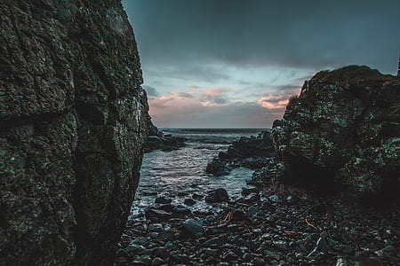 brown boulder and stones on seashore during daytime thumbnail