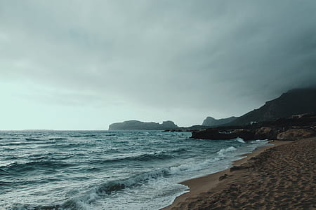 seashore and mountain view during daytime thumbnail