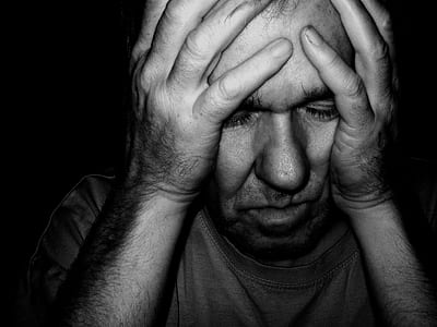 gray scale photo of man holding his face thumbnail