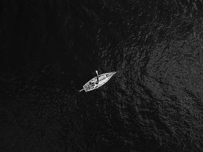 Aerial Photography Of Boat In The Middle Of Body Of Water thumbnail