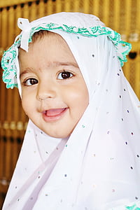 smiling baby wearing white and black polka-dot headdress thumbnail