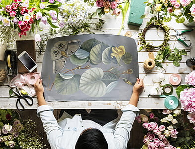 Top View Photo of Person Holding Floral Painting thumbnail