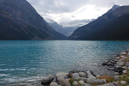 body of water near mountains at daytime thumbnail