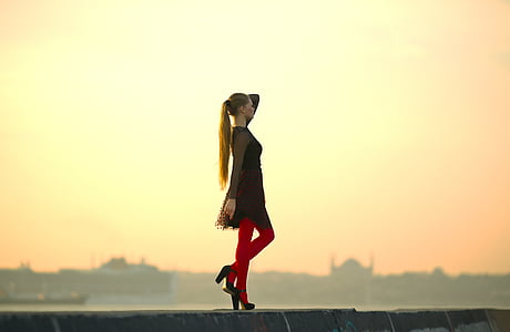 woman wears black long-sleeved mini dress stands on grey concrete surface thumbnail