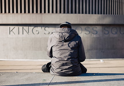 person wearing grey hoodie sitting on ground thumbnail