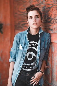 photography of person in blue denim button-up jacket leaning on the wall thumbnail