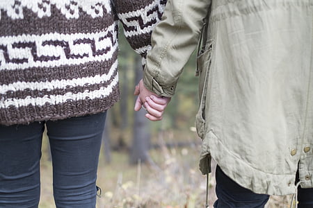 people holding hands walking on grass thumbnail