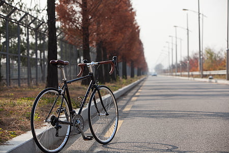 black and brown road bike on road thumbnail