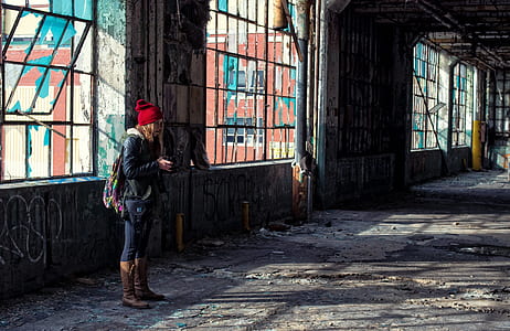 woman in red beanie standing infront of window during daytime thumbnail