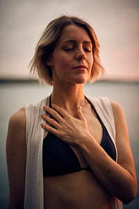 selective photography of woman holding her chest thumbnail