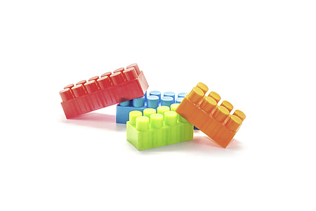 four assorted-color interlocking brick toys on white background thumbnail