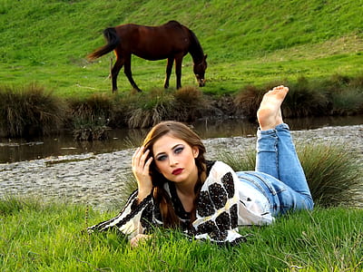 woman lying on grass near body of weater thumbnail