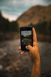 man taking a photo of a mountain thumbnail