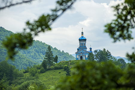 Blue Dome Building Surrounded by Tall Trees Taken Under White Clouds thumbnail