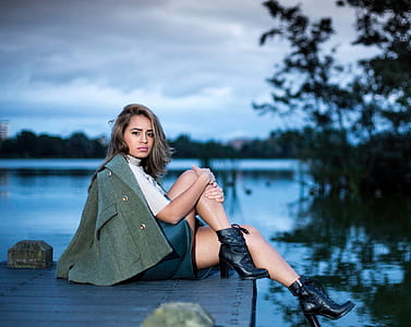 woman sitting on dock near tree thumbnail