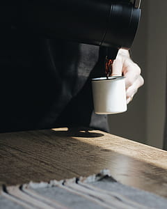 person holding teapot pouring cup with coffee thumbnail