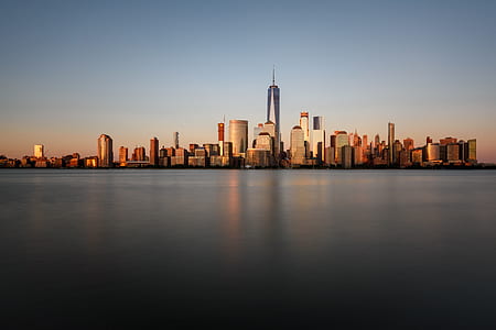 city buildings beside body of water at golden hour thumbnail