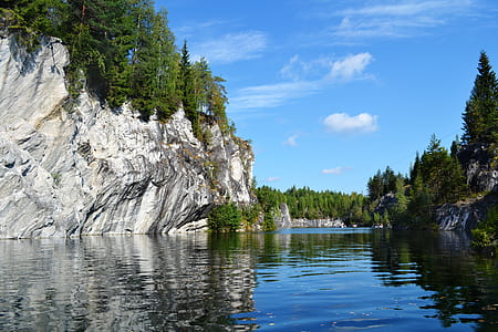 stone hill near lake under blue sky at daytime thumbnail