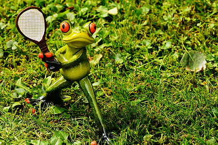 frog holding tennis racket garden decor on grass thumbnail