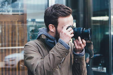 man shooting photo through DSLR camera during daytime thumbnail