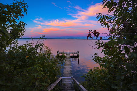 empty lake dock under blue skies thumbnail