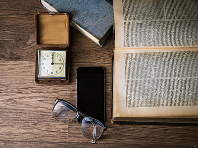 black framed eyeglasses near black Android smartphone and book page thumbnail