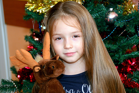 girl carrying brown moose plush toy thumbnail