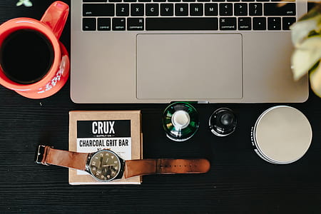 green glass bottle beside laptop thumbnail