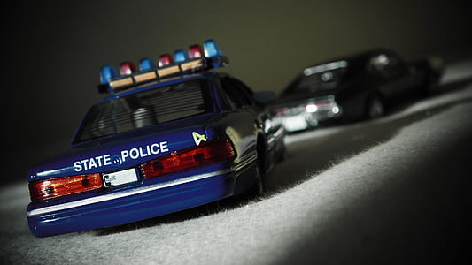 close-up photography of police car and grey coupe die-cast models thumbnail