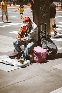 man playing guitar on street during daytime thumbnail
