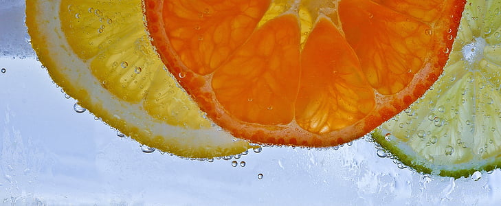 slices of lemon, orange fruit, and lime in water thumbnail