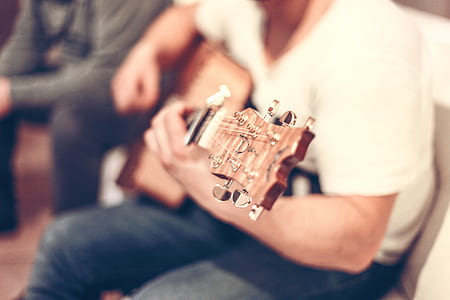 man holding brown acoustic guitar thumbnail