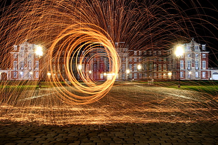steel wool photography in front of red concrete building thumbnail