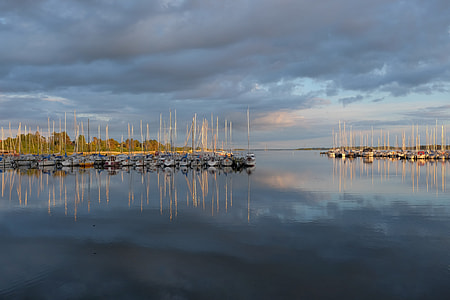 boats on dock under thick gray clouds photo thumbnail
