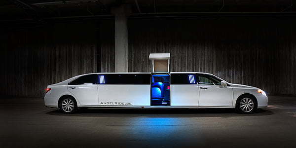opened door of white limousine parked near wall thumbnail