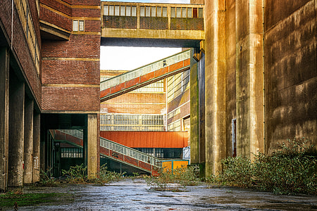 landscape photo of brown and orange concrete building with intermodal containers thumbnail