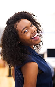 woman wearing blue collared sleeveless shirt smiling during daytime thumbnail