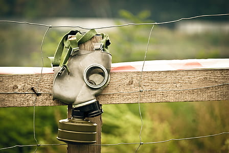 gray gas mask hanging on wire fence thumbnail