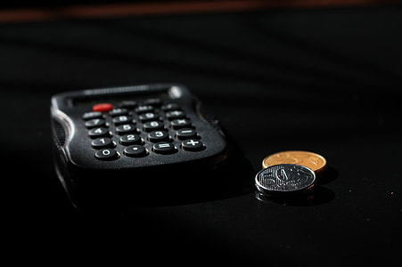 black calculator beside of two round coins thumbnail