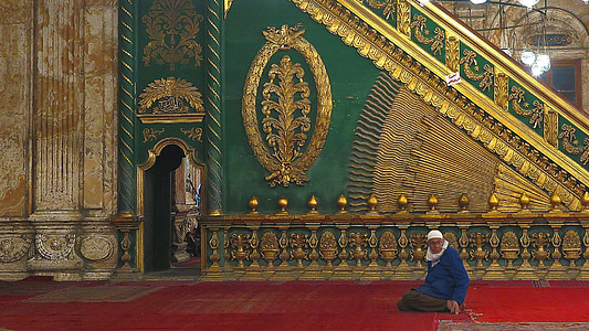 man sitting on red floor beside green and yellow wall thumbnail