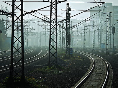 photo of black train rail surrounded by transmission towers thumbnail