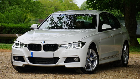 white BMW 4-Series sedan parked near green leaf tree thumbnail
