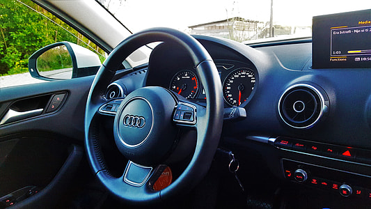 person taking photo of black Audi steering wheel thumbnail