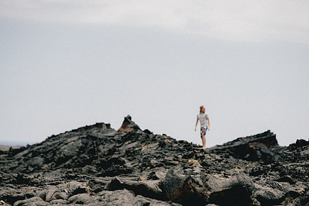 person walking on gray rock surface thumbnail