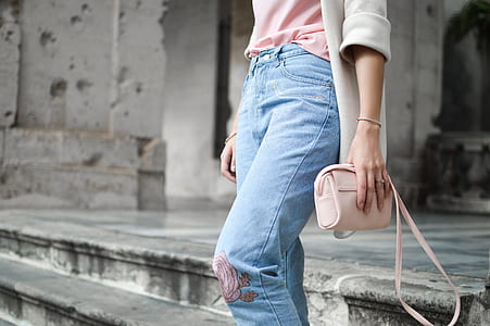 person on stair holding sling bag thumbnail